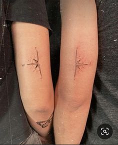 two people with matching tattoos on their legs, one has a compass and the other has an arrow