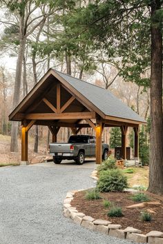 a truck is parked under a covered parking lot in front of some trees and bushes