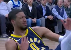 two men playing basketball in front of an audience