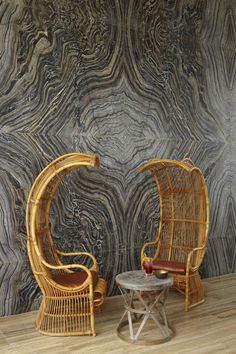 two wicker chairs sitting next to each other on top of a hard wood floor