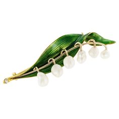 Marcus & Co green enamel and pearl lily of the valley antique yellow gold brooch circa 1900. * ABOUT THIS ITEM: #P-DJ128J. Scroll down for detailed specifications. This exquisite lily of the valley brooch features green enamel and six unique pearls. The stem end of the flower is set with a round diamond. Lily of the valley flowers have been steeped in legend and folklore for centuries. It is the birth flower for the month of May and often forms bridal bouquets. Queen Elizabeth II called it her f River Pearls, Lily Of The Valley Flowers, Valley Flowers, Elisabeth Ii, Month Of May, Isabel Ii, Gold Brooch, Fine Art Jewelry, Antique Brooches