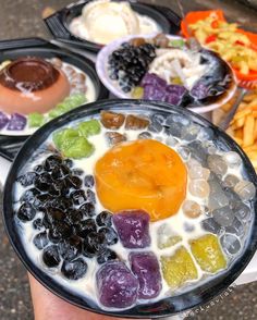 there are many different types of food in the trays on the table, including fruit and ice cream