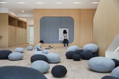 a person sitting on the floor in front of a whiteboard with black and blue balls