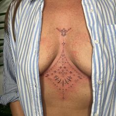 a woman's chest with an intricate design on the top and bottom part of her breast