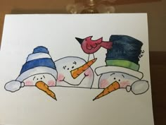 two snowmen with hats and carrots on their heads