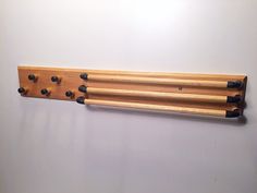 a wall mounted coat rack with five coats hanging on it's sides and four pegs in the middle