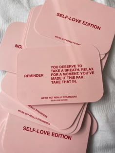 four pink self love cards on top of a white sheet