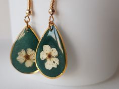 The flowers were picked by me, put between books' pages to dry. Later they were poured with epoxy resin in these droplet shaped gold frame and finally assembled into earrings. I love how they came out, being so one of a kind!  The earrings are made with epoxy resin and stainless steel. They are very lightweight. Enjoy wearing them as much as I enjoyed creating them! Epoxy Resin, Gold Frame, Dark Green, Jewelry Earrings Dangle, Dangle Drop Earrings, Dangle Earrings, Handmade Items, Jewelry Earrings, Gift Card