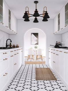 a kitchen with black and white tile flooring and pendant lights hanging from the ceiling