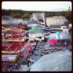 an aerial view of the amusement park with many rides and people walking around in it