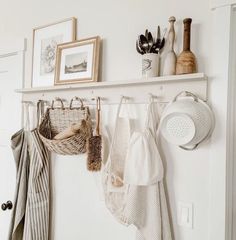 there is a rack with pots and pans hanging on the wall next to other kitchen utensils