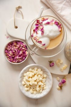 a cup of hot chocolate with marshmallows and rose petals on the side