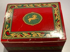 an open red box with gold trim and a horse on it