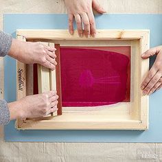 three people are working on an art project with their hands and one is holding a piece of wood