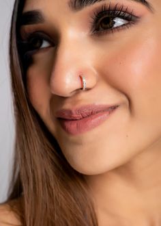 a close up shot of a woman's face with her nose ring in the middle