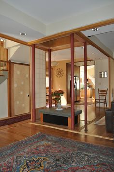 an open living room and dining area with wood flooring, furniture and rugs