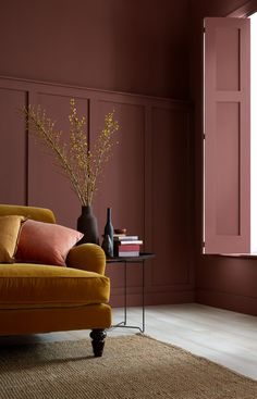 a living room with pink walls and orange furniture in front of a large open window