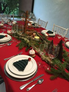 a table set for christmas dinner with place settings