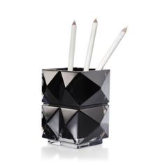 a black and white pen holder with three pencils in it