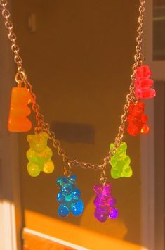 multicolored teddy bear charms hanging from a silver chain on a window sill