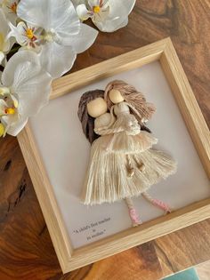 an image of a doll in a frame with flowers