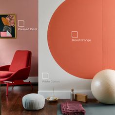 a living room with an orange and white wall next to a large ball on the floor