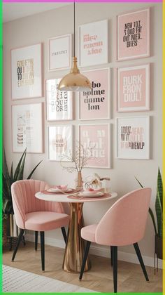 two pink chairs sitting at a table in front of pictures on the wall above them