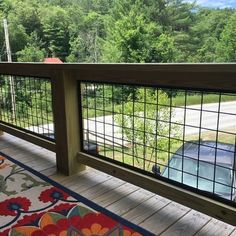 a car is parked on the side of a road through a fenced in porch