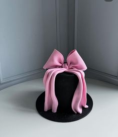 a black hat with a pink bow on top