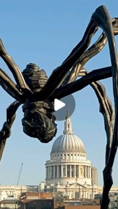 a giant spider sculpture in front of the capital building with an image of st paul's cathedral in the background