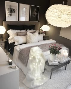 a bedroom with white fur and lights on the bed