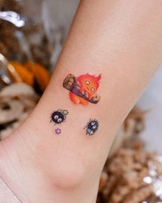 a small tattoo on the ankle of a girl with an orange fox and other animals