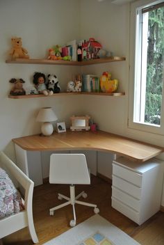 there is a desk and chair in the corner of this room with shelves on the wall