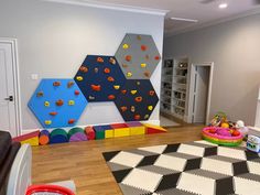 a child's playroom with climbing walls and toys on the floor in front of it