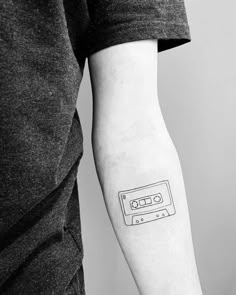 a black and white photo of a person's arm with a tape recorder tattoo on it