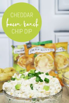 cheddar bacon ranch dip in a glass bowl with green onions and cilantro