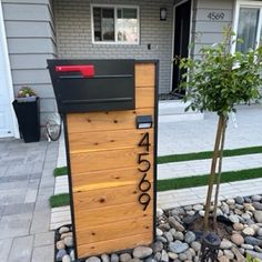 a mailbox sitting on top of a pile of rocks in front of a house