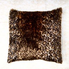 a brown and black animal print pillow on a white surface