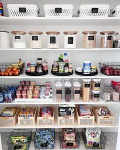 a pantry filled with lots of food and storage bins on top of white shelves