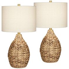 two woven lamps with white shades on each lamp and the same light in between them