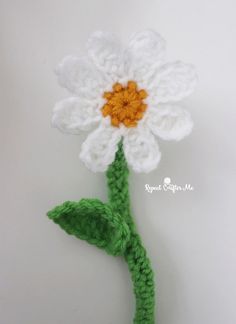 a crocheted white flower with green stems