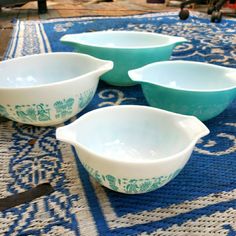 four blue and white bowls sitting on top of a table