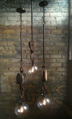 three light fixtures hanging from a brick wall