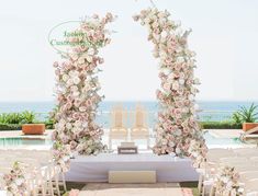 an outdoor ceremony setup with white chairs and pink flowers on the aisle, overlooking the ocean