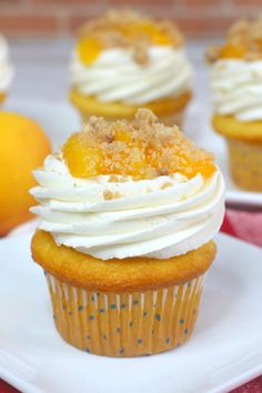 cupcakes with white frosting and fruit on top