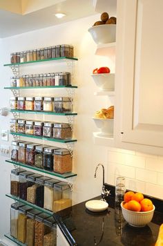 the shelves in the kitchen are filled with spices