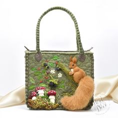 a small handbag with a squirrel on it's side and mushrooms in the background