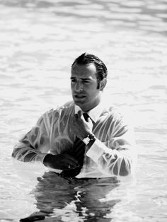 a man standing in the water tying his tie