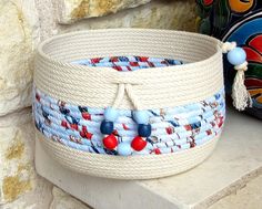 a white basket with blue and red beads on it