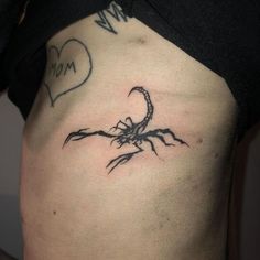 a scorpion tattoo on the side of a woman's stomach, with a heart in the background